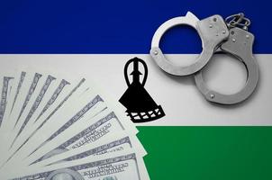 Lesotho flag  with handcuffs and a bundle of dollars. The concept of illegal banking operations in US currency photo