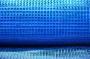 Close-up texture of a blue reinforcing mesh rolled up in a roll. Building resource for reinforcing walls in the process of their warming photo