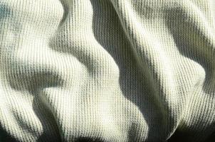 Fabric texture of a soft yellow knitted sweater. Macro image of the structure of bindings in yarns photo