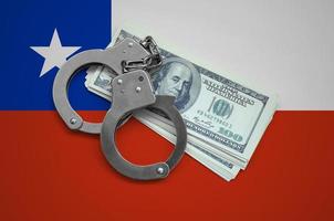 Chile flag  with handcuffs and a bundle of dollars. Currency corruption in the country. Financial crimes photo