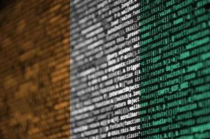 Ivory Coast flag  is depicted on the screen with the program code. The concept of modern technology and site development photo