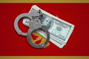 Montenegro flag  with handcuffs and a bundle of dollars. Currency corruption in the country. Financial crimes photo