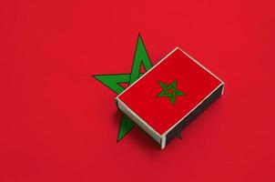 Morocco flag  is pictured on a matchbox that lies on a large flag photo