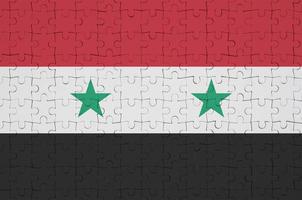 Syria flag  is depicted on a folded puzzle photo