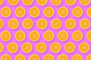 Pattern of an orange citrus slices on bright purple background photo