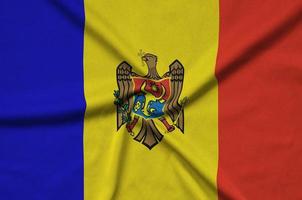Moldova flag  is depicted on a sports cloth fabric with many folds. Sport team banner photo