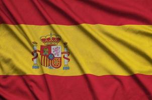 Spain flag  is depicted on a sports cloth fabric with many folds. Sport team banner photo