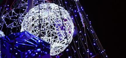 Fragment of the New Year tree. A lot of round lights of blue color are located on a conical frame photo