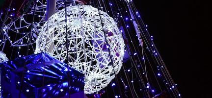 fragmento del árbol de año nuevo. muchas luces redondas de color azul están ubicadas en un marco cónico foto