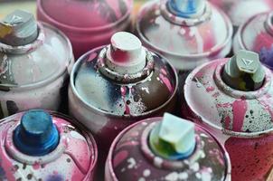 A lot of used spray cans of paint close-up. Dirty and smeared cans for drawing graffiti. The concept of a sweeping and careless drawing of paint. Creative art image photo