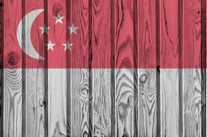 Singapore flag depicted in bright paint colors on old wooden wall. Textured banner on rough background photo