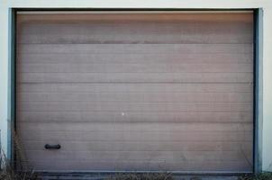 The texture of a painted metal gate from a brick garage photo