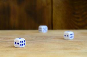 A few dice lies on the surface of natural wood. Items for generating numbers from one to six in the form of points that are painted on the side of cubes. The concept of gambling photo