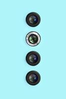 unas pocas lentes de cámara con una apertura cerrada se encuentran en el fondo de textura de papel de color azul pastel de moda foto