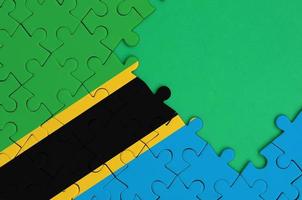 Tanzania flag  is depicted on a completed jigsaw puzzle with free green copy space on the right side photo