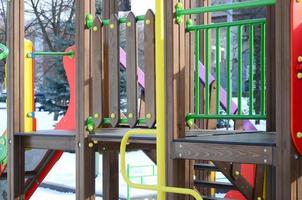 Fragment of a playground made of plastic and wood, painted in different colors photo