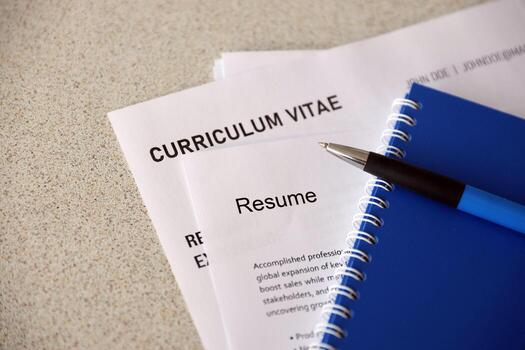 Top view of stack of office documents including resume and cv forms on the desk close to pen and notepad. Job seeking process. Hunting for workplace photo