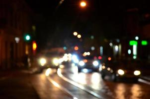 escena nocturna borrosa de tráfico en la carretera. imagen desenfocada de coches que viajan con faros luminosos. arte bokeh foto