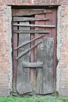 Boarded up wooden door to an old abandoned house photo