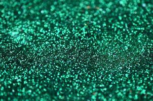 A huge amount of green decorative sequins. Background texture with shiny, small elements that reflect light in a random order. Glitter texture photo