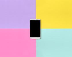 Modern smartphone with black screen on texture background of fashion pastel blue, yellow, violet and pink colors paper in minimal concept photo