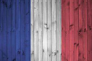 bandera de francia representada en colores de pintura brillante en la pared de madera vieja. banner texturizado sobre fondo áspero foto