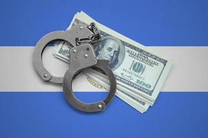 Nicaragua flag  with handcuffs and a bundle of dollars. Currency corruption in the country. Financial crimes photo