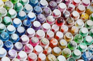 A pattern from a many nozzles from a paint sprayer for drawing graffiti, smeared into different colors. The plastic caps are arranged in many rows forming the color of the rainbow photo