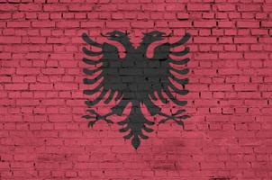 Albania flag is painted onto an old brick wall photo