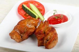 Pork BBQ on the plate and wooden background photo