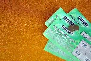Close up view of green lottery scratch cards. Many used fake instant lottery tickets with gambling results. Gambling addiction photo