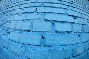 Large brick wall, painted in blue. Fisheye photo with pronounced distortion