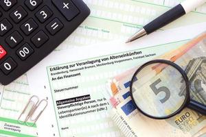 German statement on the assessment of retirement income with calculator and european money close up. The concept of taxation and accountant paperwork Germany photo