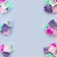 Piles of a small colored gift boxes with ribbons lies on a violet background photo