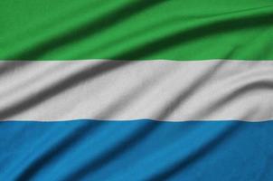 Sierra Leone flag  is depicted on a sports cloth fabric with many folds. Sport team banner photo