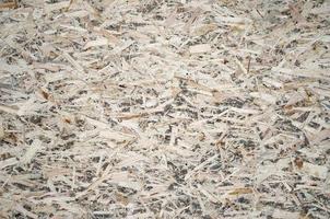 An old oriented strand board OSB , fiberboard background of texture. Sheet is made of brown wood chips pressed together into a wooden floor photo