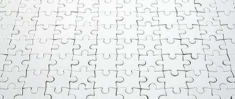 Close up of a white jigsaw puzzle in assembled state in perspective. Many components of a large whole mosaic are united photo