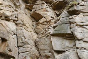 Light coarse natural rock stone background. Mining cliff rough front surface. Big limestone stack backdrop. Heavy grunge damaged granite block texture photo