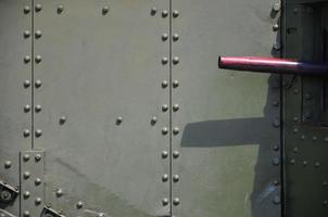 The texture of the wall of the tank, made of metal and reinforced with a multitude of bolts and rivets. Images of the covering of a combat vehicle from the Second World War with a guided machine gun photo