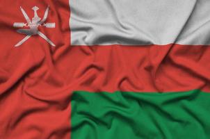 Oman flag  is depicted on a sports cloth fabric with many folds. Sport team banner photo