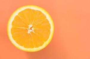 Top view of a one orange fruit slice on bright background in orange color. A saturated citrus texture image photo