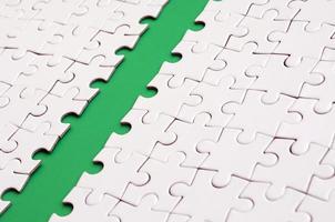 The green path is laid on the platform of a white folded jigsaw puzzle. Texture image with copy space for text photo