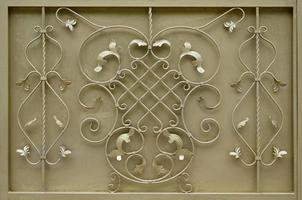 The texture of the golden metal gate with a beautiful floral pattern of forged metal photo
