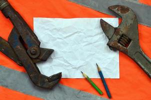 Adjustable wrenches and a sheet of paper with two pencils photo