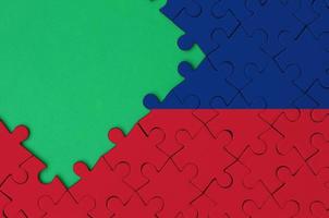 Liechtenstein flag  is depicted on a completed jigsaw puzzle with free green copy space on the left side photo