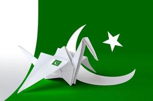 Pakistan flag depicted on paper origami crane wing. Handmade arts concept photo