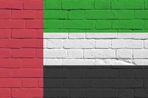 United Arab Emirates flag depicted in paint colors on old brick wall. Textured banner on big brick wall masonry background photo