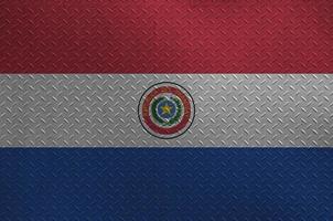 Paraguay flag depicted in paint colors on old brushed metal plate or wall closeup. Textured banner on rough background photo