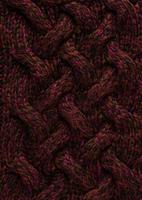Texture of smooth knitted dark sweater with pattern. Top view, close-up. Handmade knitting wool or cotton fabric texture. Background of knitting patterns with a vertical large Braid Cable. photo