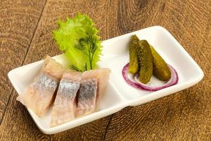 Herring fillet in a bowl on wooden background photo